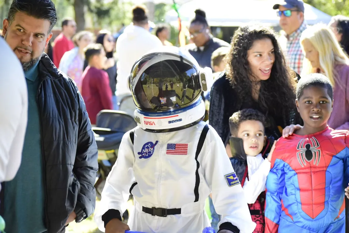 Kids dressed as an astronaut and Spider-Man at a Halloween parade