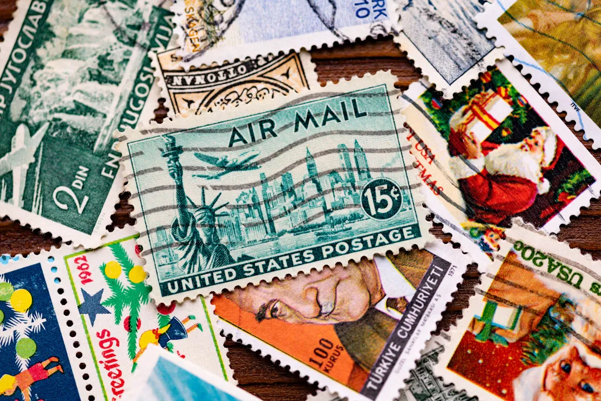 A pile of vintage postage stamps, including a 15-cent United States airmail stamp