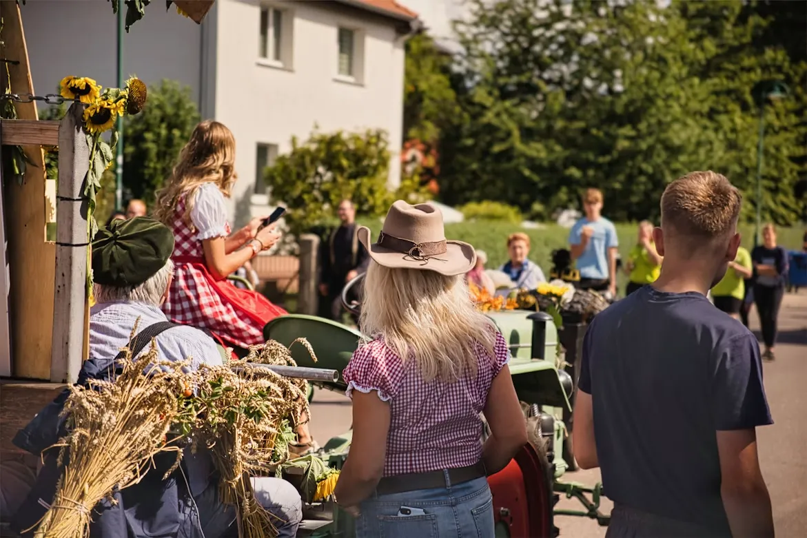 Kids and parents walking past straw bales at a fall farm festival