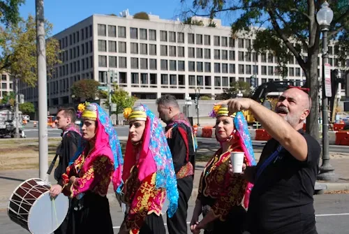 Dancers in traditional Turkish dress and a drummer performing on a city street